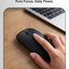 Hand using a black wireless mouse on a wooden desk with a laptop in the background, featuring the text 'Pure Performance' and 'Pure Focus. Daily Power.